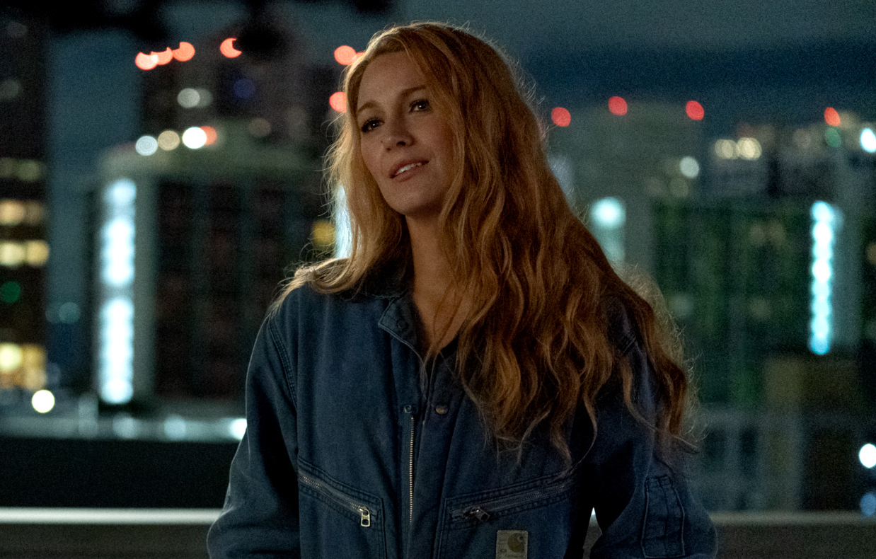 Blake Lively adossée à un mur dans une combinaison en jean dans le film Jamais plus - It Ends With Us.