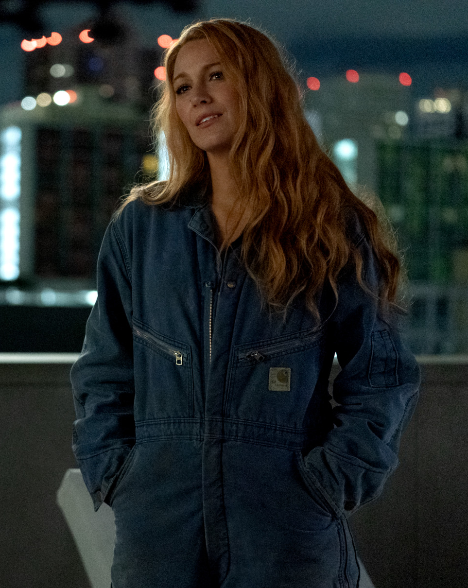 Blake Lively adossée à un mur dans une combinaison en jean dans le film Jamais plus - It Ends With Us.