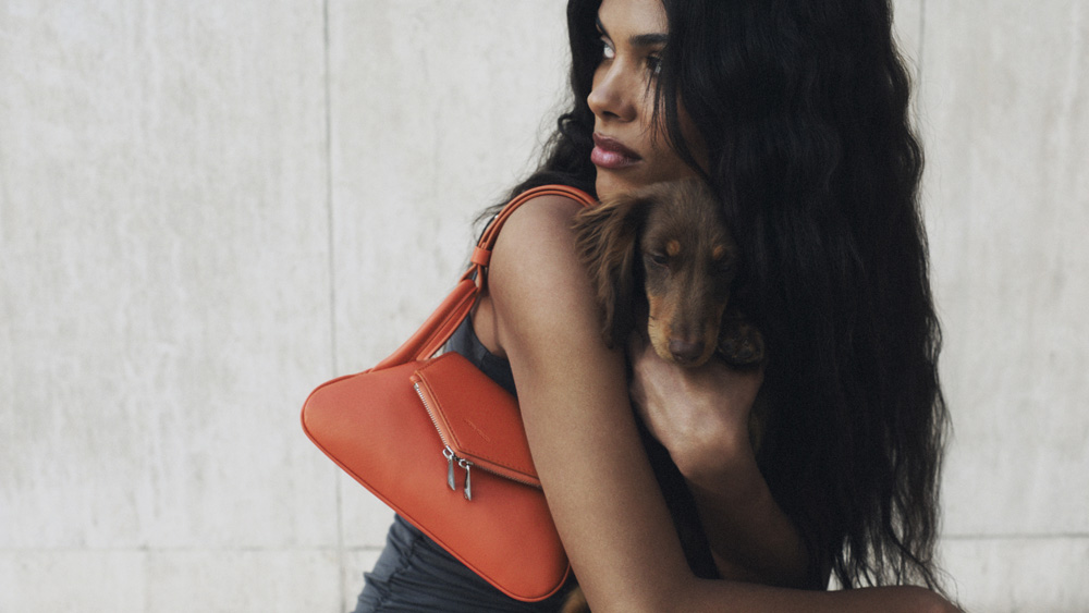 Tina Kunakey égérie de la campagne Amina Muaddi avec le sac Orange Gemini
